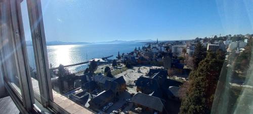 a view of a city and the water from a window at El encanto del lago in San Carlos de Bariloche