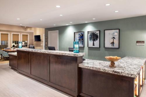 a lobby with a reception counter with paintings on the wall at Residence Inn Los Angeles Torrance/Redondo Beach in Torrance