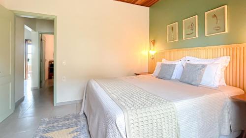 Un dormitorio con una gran cama blanca en una habitación. en Casas Gengibre, en Alto Paraíso de Goiás