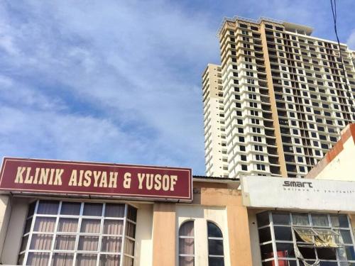 a building with a sign in front of a tall building at Apartment at KLIA Sepang in Kampong Jijan Hilir