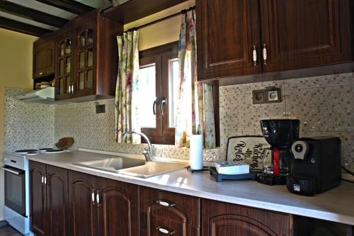a kitchen with wooden cabinets and a sink and a window at Simon's Walnut Farm in Mavrokhórion