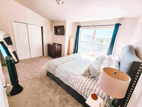 a bedroom with a bed and a window and a couch at Palmer Lake near AF Academy Pet Friendly King Bed 4 TVs in Palmer Lake