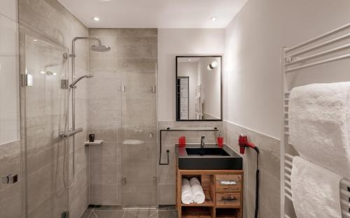 ein Bad mit einem Waschbecken und einer Dusche in der Unterkunft Hotel Traumschmiede in Unterneukirchen