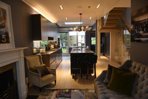 a living room with a couch and a kitchen at Luxury 4 Bedrooms 5 Baths 2 Receptions Family House with Garden Chelsea in London