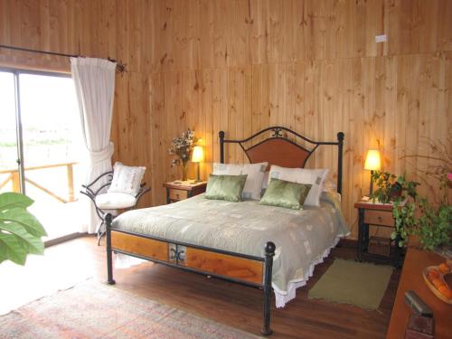 a bedroom with a bed and a wooden wall at B&B Shambala HN in Pelarco