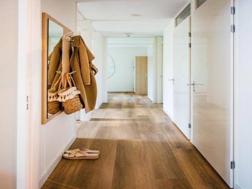 a hallway with wood floors and a hallway with shoes at Holiday Home in Voorthuizen near Veluwe in Voorthuizen