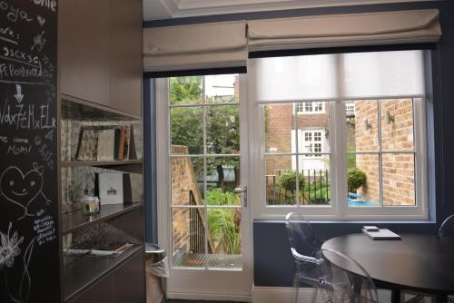 a dining room with a table and a window at Luxury 4 Bedrooms 5 Baths 2 Receptions Family House with Garden Chelsea in London