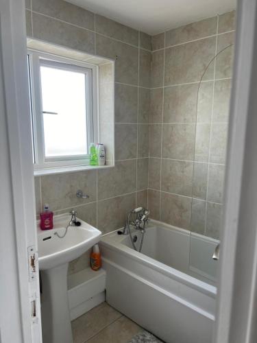 a bathroom with a tub and a sink and a bath tub at Sleeps 7 in Pembrokeshire