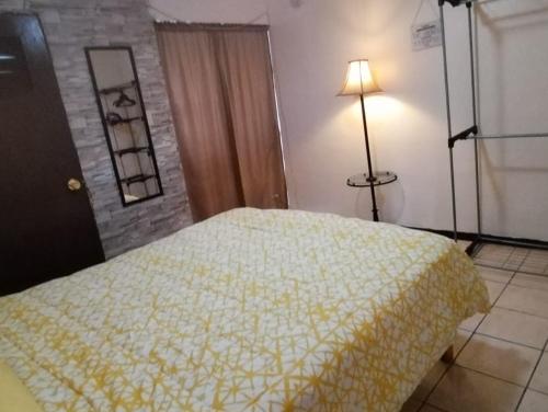 a bedroom with a bed with a yellow blanket at departamento cd juarez in Ciudad Juárez