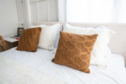 a bed with white sheets and pillows on it at Granbalaio Hostel in Blumenau