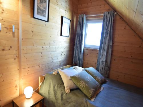 a bedroom with a bed in a wooden cabin at Holiday Home by Lake Zarnowieckie with Sauna in Nadole