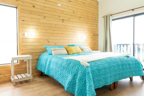 a bedroom with a bed with a wooden wall at Casa en La Estancia in La Estancia