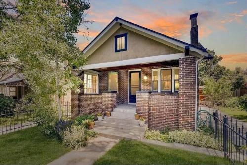 a brick house with a fence in front of it at Quiet, Immaculate Denver Home Relax or Work Near Dining & Attractions! in Denver