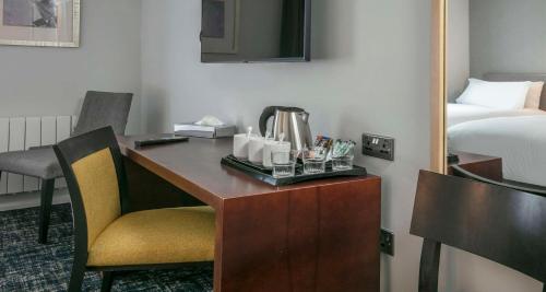 a hotel room with a desk with a bed and a mirror at Best Western Appleby Park Hotel in Tamworth