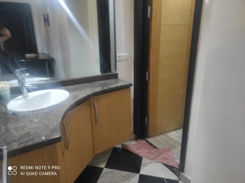 a bathroom with a sink and a mirror at Appartement Alkheir in Agadir
