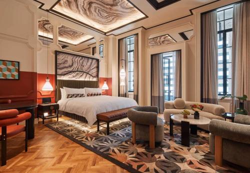 a bedroom with a bed and a living room at QT Singapore in Singapore