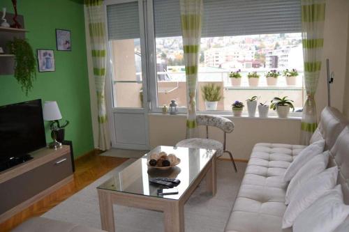 Una sala de estar con un sofá blanco y una mesa. en M apartment, en Skopje