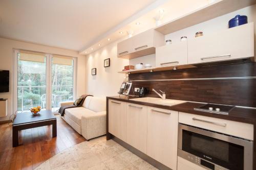 a kitchen and living room with a couch and a table at Apartament Jurata in Jurata