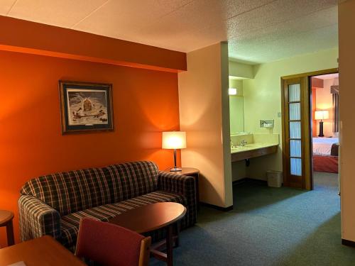 a hotel room with a couch and a bed at Northwoods Inn & Suites - Blackduck in Blackduck