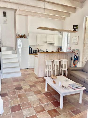 un salon avec une table et une cuisine dans l'établissement Maison de ville Chai Saint Martin de Ré, à Saint-Martin-de-Ré