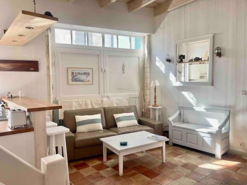 un salon avec un canapé et une table dans l'établissement Maison de ville Chai Saint Martin de Ré, à Saint-Martin-de-Ré