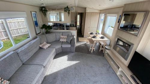 a living room with a couch and a table at Cosy Holiday Home at Seton Sands near Edinburgh and North Berwick in Port Seton