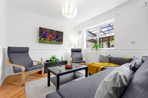a living room with a couch and a table at Cozylease 3 Bedroom Canary Wharf Family,Workcation, Fast WiFi, Workspace,1 stop to City in London