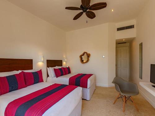 a bedroom with two beds and a ceiling fan at HM Playa del Carmen in Playa del Carmen