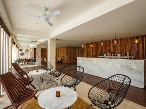 a room with chairs and tables and a bar at HM Playa del Carmen in Playa del Carmen