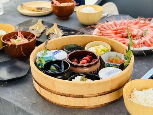 a wooden bowl filled with food on a table at LOCA THE JUNPU Moroyose in Moroyose
