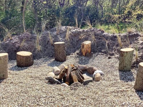 a group of logs and stump stumps in a garden at 5 star holiday home in Vestervig-By Traum in Vestervig