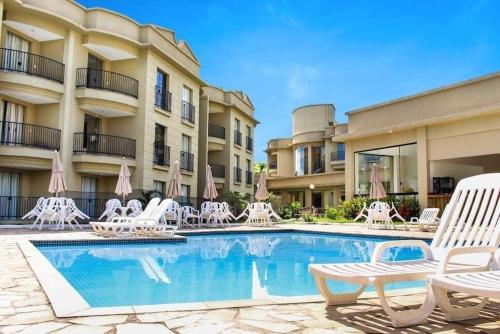 una piscina con sedie e un hotel di Flat Aldeia das Águas a Volta Redonda