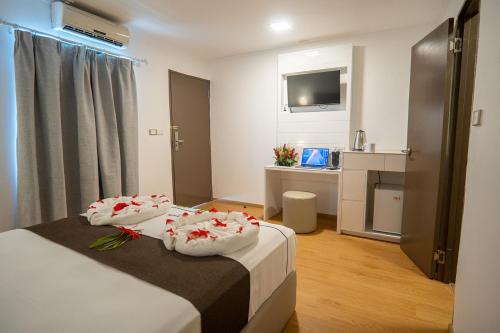 a hotel room with two beds with flowers on them at Airport Ace Hotel in Nadi