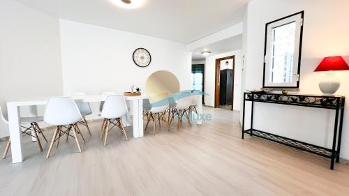 a living room with a dining room table and white chairs at Villa Golfinho by Sunny Deluxe in Albufeira