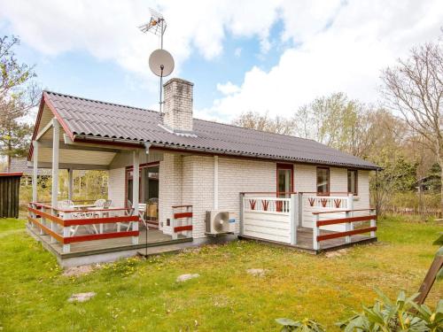 a small white house with a porch at 6 person holiday home in Glesborg in Glesborg