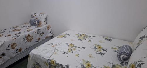 a bedroom with a bed with a floral bedspread at Suite da Barra in Barra Grande