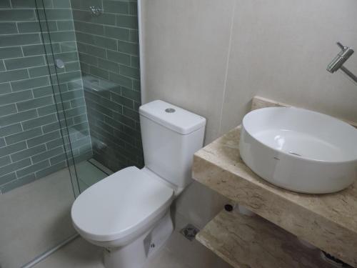 a bathroom with a toilet and a sink and a shower at Apartamento Praia Grande in Ubatuba