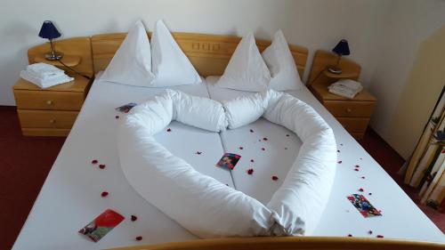 a bed with a white comforter with confederacies at Frühstückspension Bachseitenhof in Radstadt