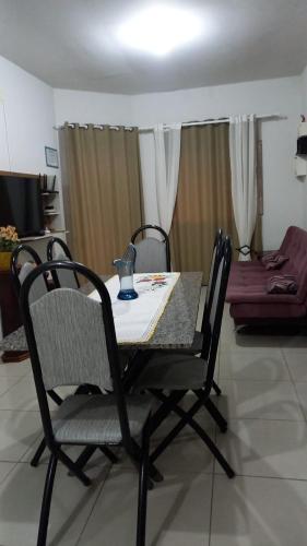 a dining table and chairs in a living room at Lar do Sossego in Araquari