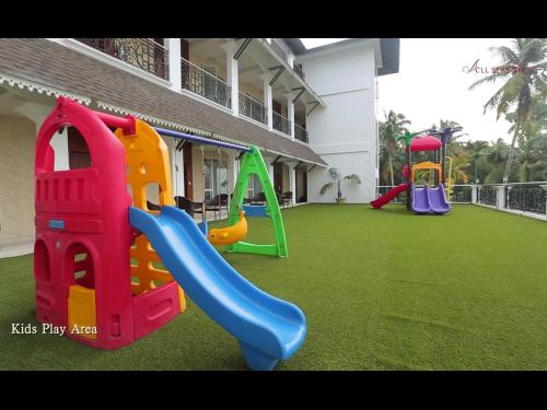 a playground with a slide on a lawn at Hotel All Season in Kollam