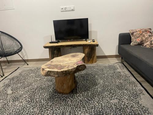 a living room with a wooden table with a television at Casa Rural - Quinze in Rabal