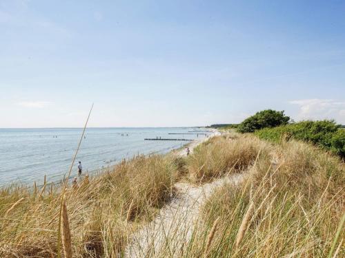 a person standing on a beach near the water at Apartment Borre VIII in Borre