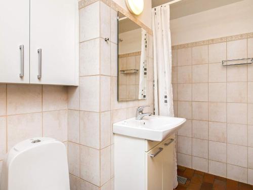 a bathroom with a sink and a toilet and a mirror at 6 person holiday home on a holiday park in Faaborg in Fåborg