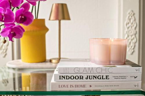 two books on a table with a candle and flowers at Charming Hideaway Apartment Near St Kilda in Melbourne
