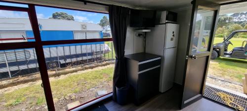 an rv with a view of a truck outside a window at Urenui Beach Camp in Urenui