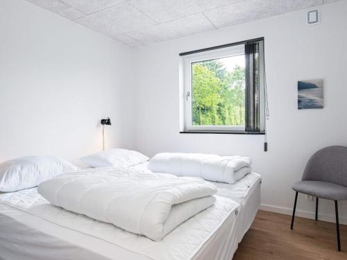 Ansagerにある10 person holiday home in Ansagerのベッドと椅子のある白い寝室