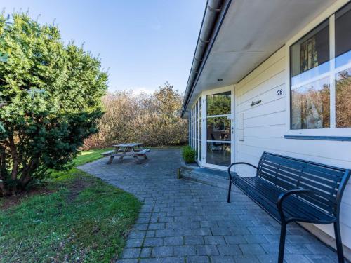 a bench next to a building with a picnic table at 8 person holiday home in Nørre Nebel in Nørre Nebel