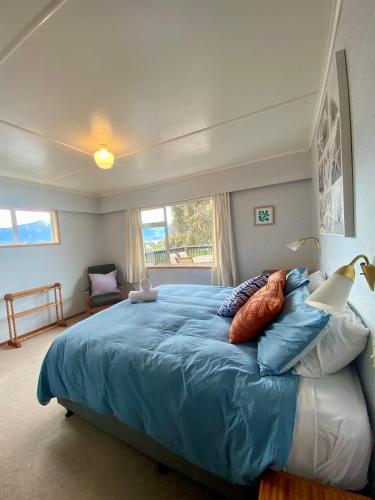 - une chambre avec un grand lit bleu et des oreillers dans l'établissement Close to the Beach with Mountain Views, à Kaikoura