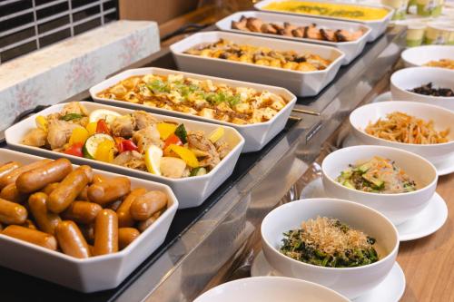 a buffet filled with different types of food in trays at Hotel Wing International Sagamihara in Sagamihara