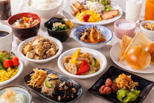 a table topped with plates of different types of food at Hotel Wing International Sagamihara in Sagamihara